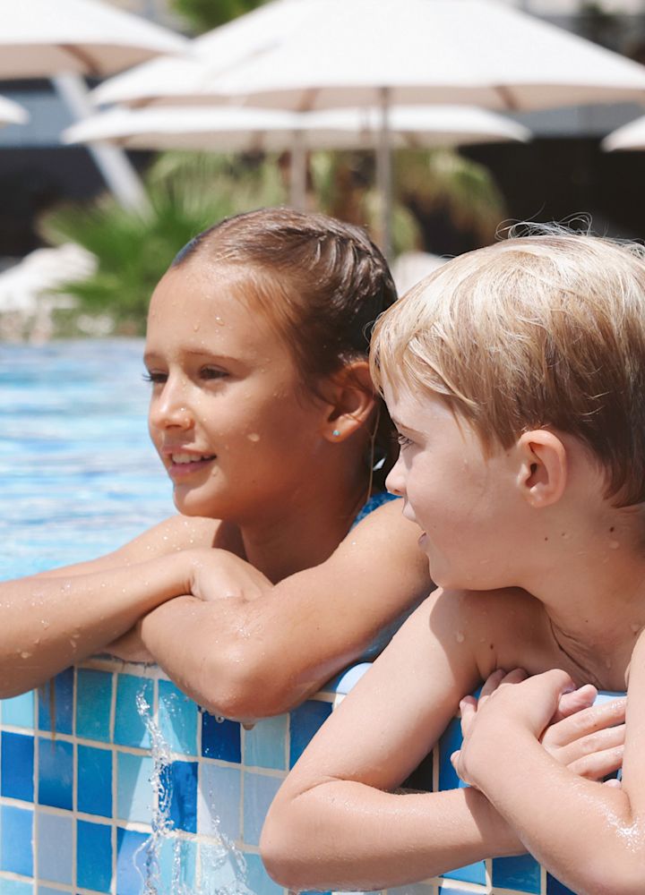 Copii bucurându-se de zona piscinei în aer liber