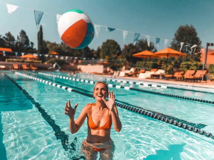 woman playing with a ball in a pool