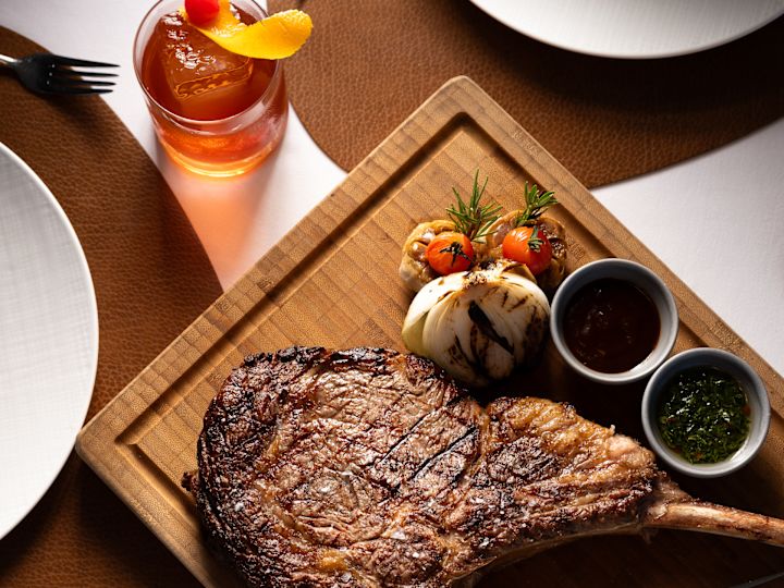 a steak on a board with sauces