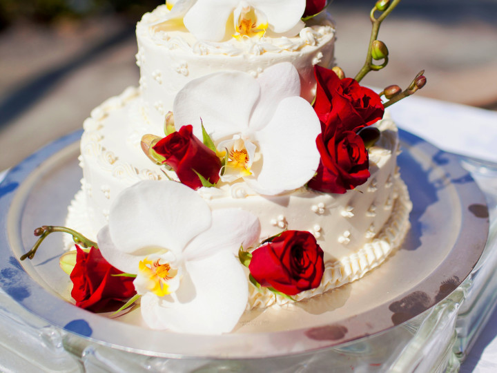 Wedding cake adorned with red and white flowers