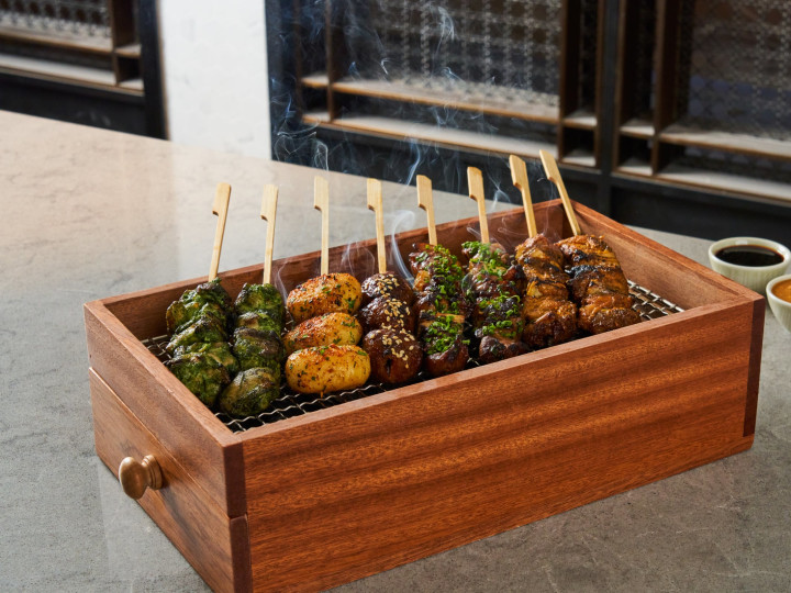 Grilled kitchen skewers presented in a wooden box.