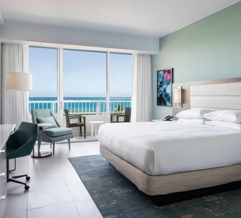 Ocean view King Room view of Bed, Desk, and TV