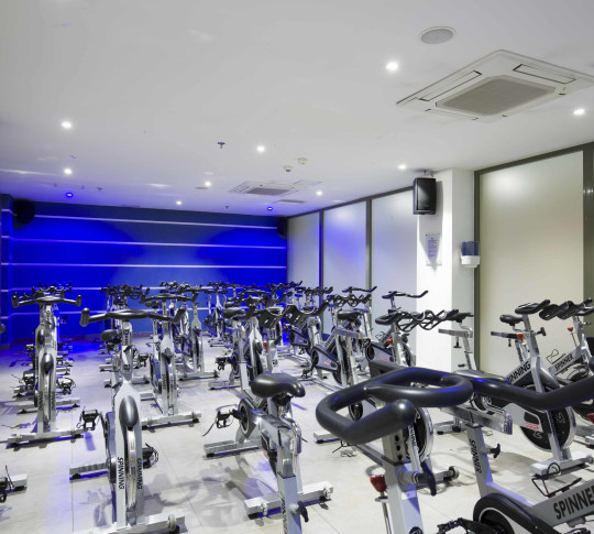 A room full of spinning bikes lined up for a class