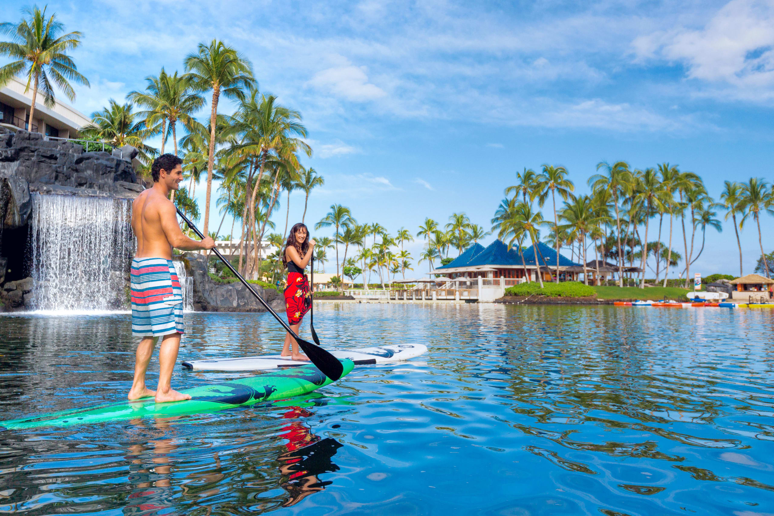 couple paddleboarding in lagoon